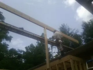 Carpenter setting a ridge beam over a new addition frame — Ice Dam Removal by Roofing Brothers in Mount Pulaski