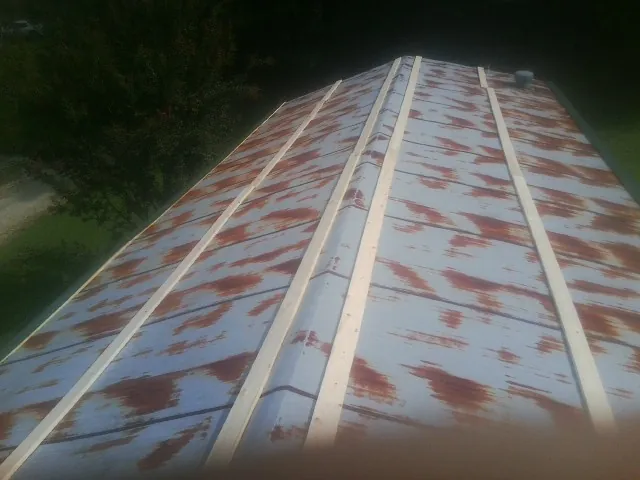 Rusted metal roof panels with new wood purlins before replacement — Storm Damage Roof Repair in Mount Pulaski by Roofing Brothers
