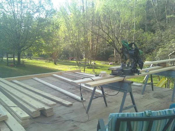 Miter saw and framing lumber on a deck under construction in Mount Pulaski