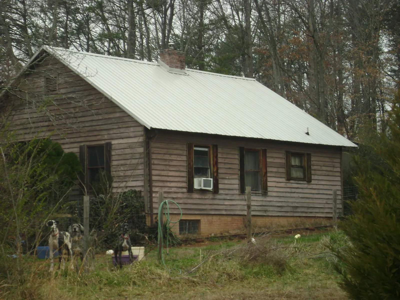 White metal roof on an old wood sided farmhouse, from a Metal Roof Installation job in Mount Pulaski